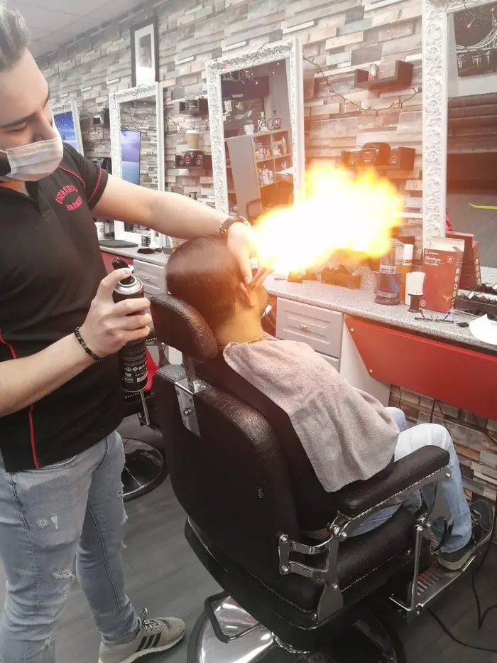 Barber performing the traditional flame ritual on a customer